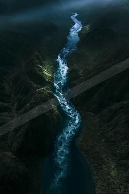 A black-toned moody photograph of valley, dam, cliff.