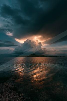 A blue hour long exposure sky scene of clouds, storm, lake.