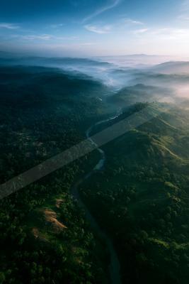 A moody water scene of river, valley, mountains.