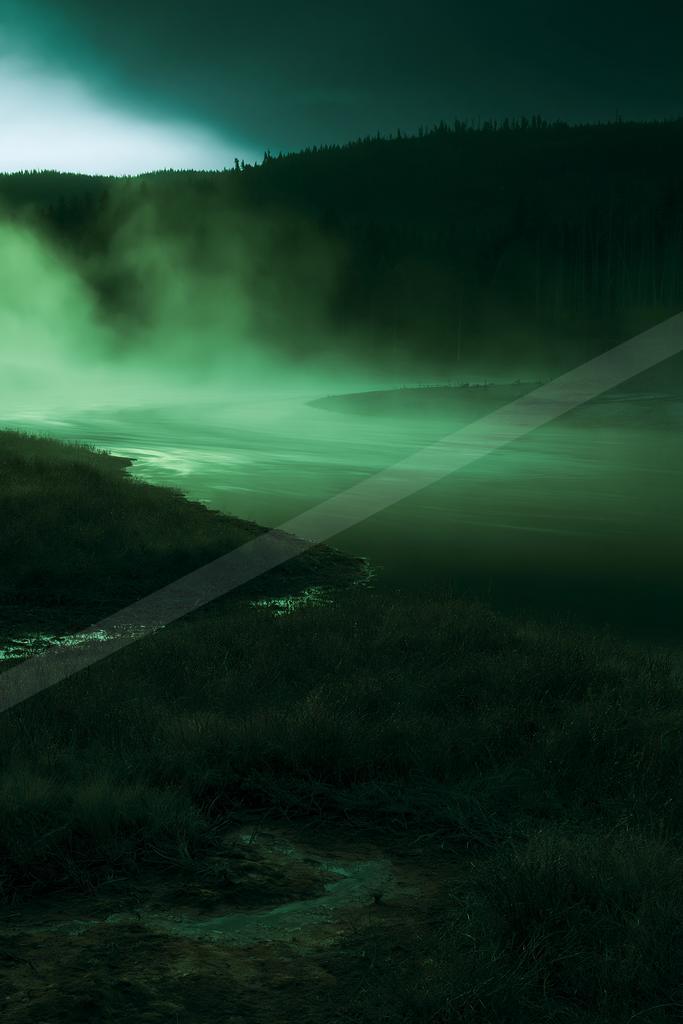 A moody water scene of river, lake, field.