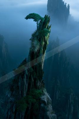 A moody landscape of mountains, fog.
