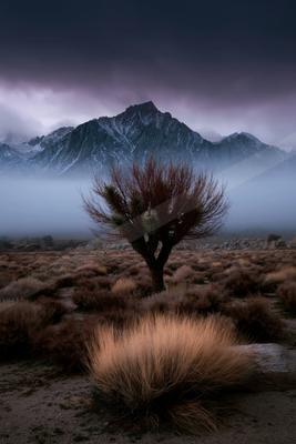 A black-toned moody photograph of volcano, alp, valley.