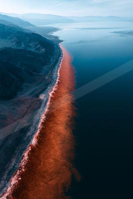 A moody water scene of beach, ocean, river.