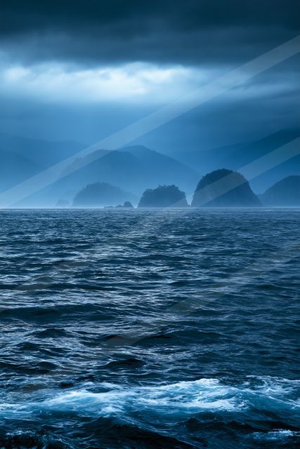 A blue hour panorama water scene of an ocean, fog.