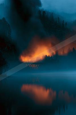 A black-toned moody photograph of volcano, lakeside, torch.