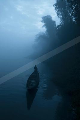 A black-toned moody photograph of canoe, paddle, wreck.