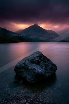 A serene long exposure water scene of lake, rocks.