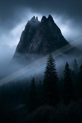 A black-toned moody photograph of alp, valley, cliff.