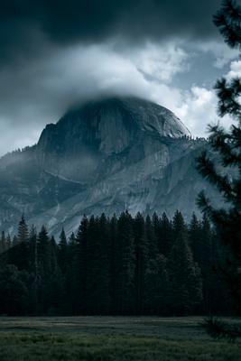 A green-toned moody photograph of alp, mountain tent, valley.