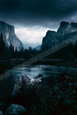 A blue hour landscape of valley, mountains, river.