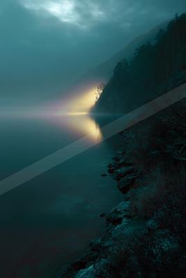 A serene mountain lake shrouded in mist at dawn, with a bright beam of light breaking through the clouds and reflecting on the calm water, rocky shoreline in th