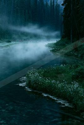 A black-toned moody photograph of lakeside, geyser, valley.