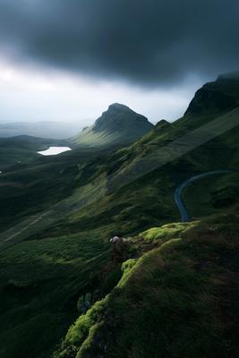 A moody landscape of valley, mountains.