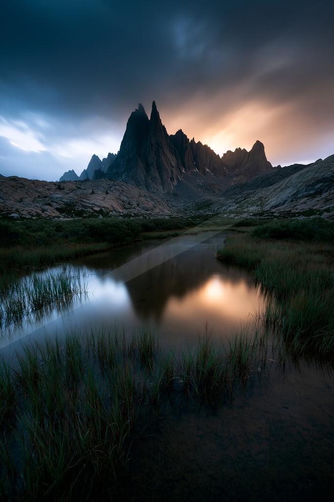 A dramatic long exposure landscape of mountains, lake, valley.