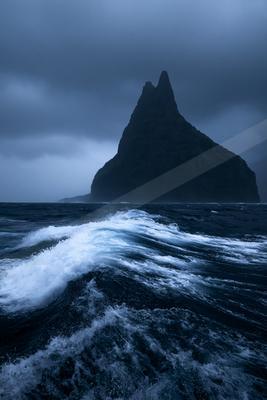 A dramatic water scene of an ocean, sand.
