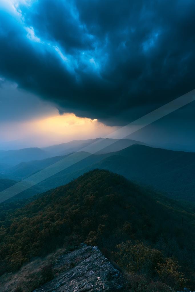 A black-toned moody photograph of alp, volcano, valley.