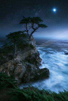 A night long exposure water scene of ocean, nebula, starry sky.