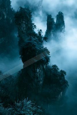 A dramatic landscape of mountains, trees, valley.