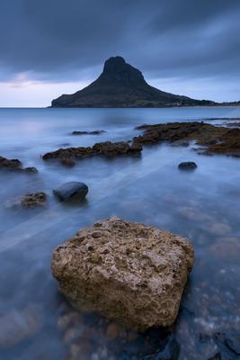 A blue hour long exposure water scene of ocean, beach, lake.