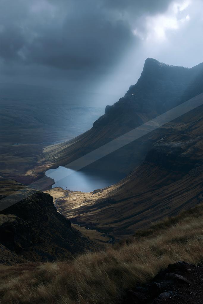 A dramatic landscape of mountains, valley, lake.