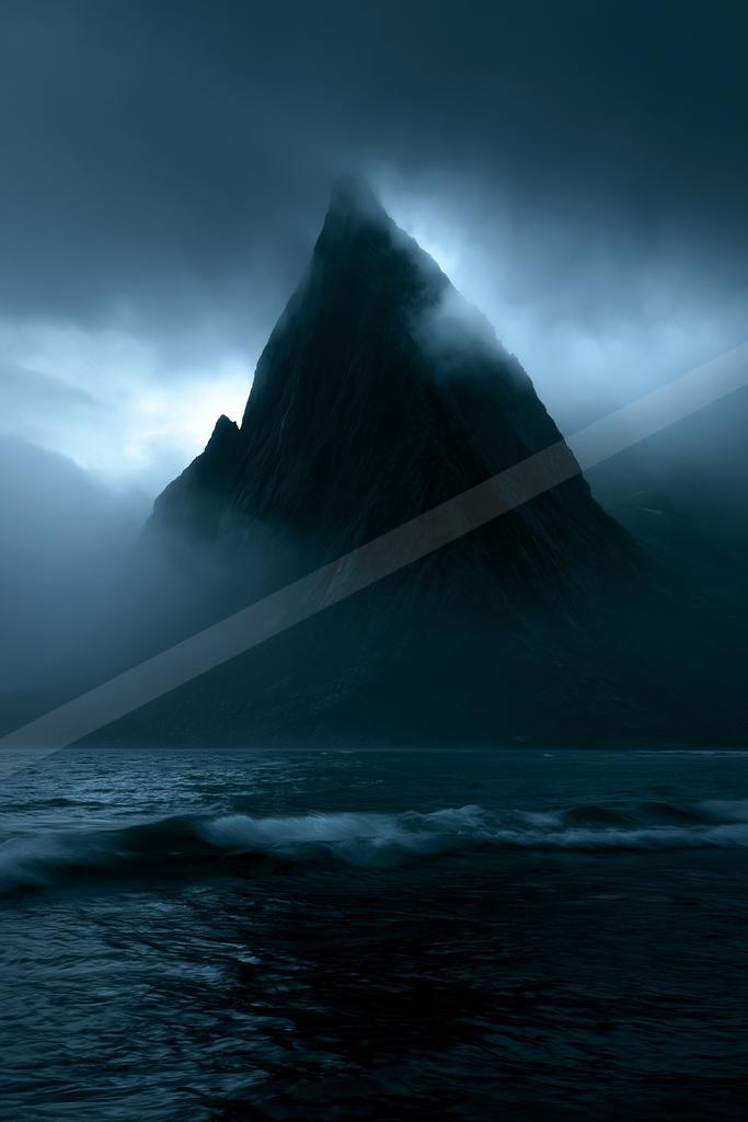 A dramatic landscape of mountains, ocean, storm.