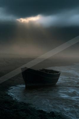 A black-toned moody photograph of seashore, wreck, boathouse.