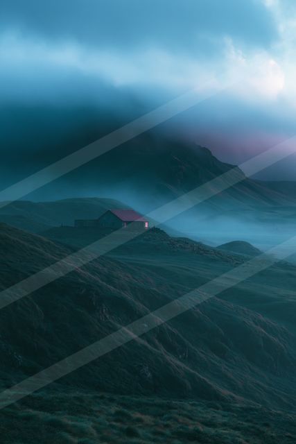 A red-roofed cabin sits alone on a mist-covered mountain slope under a cloudy sky.