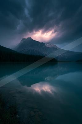 A blue hour water scene of lake, storm, reflection.