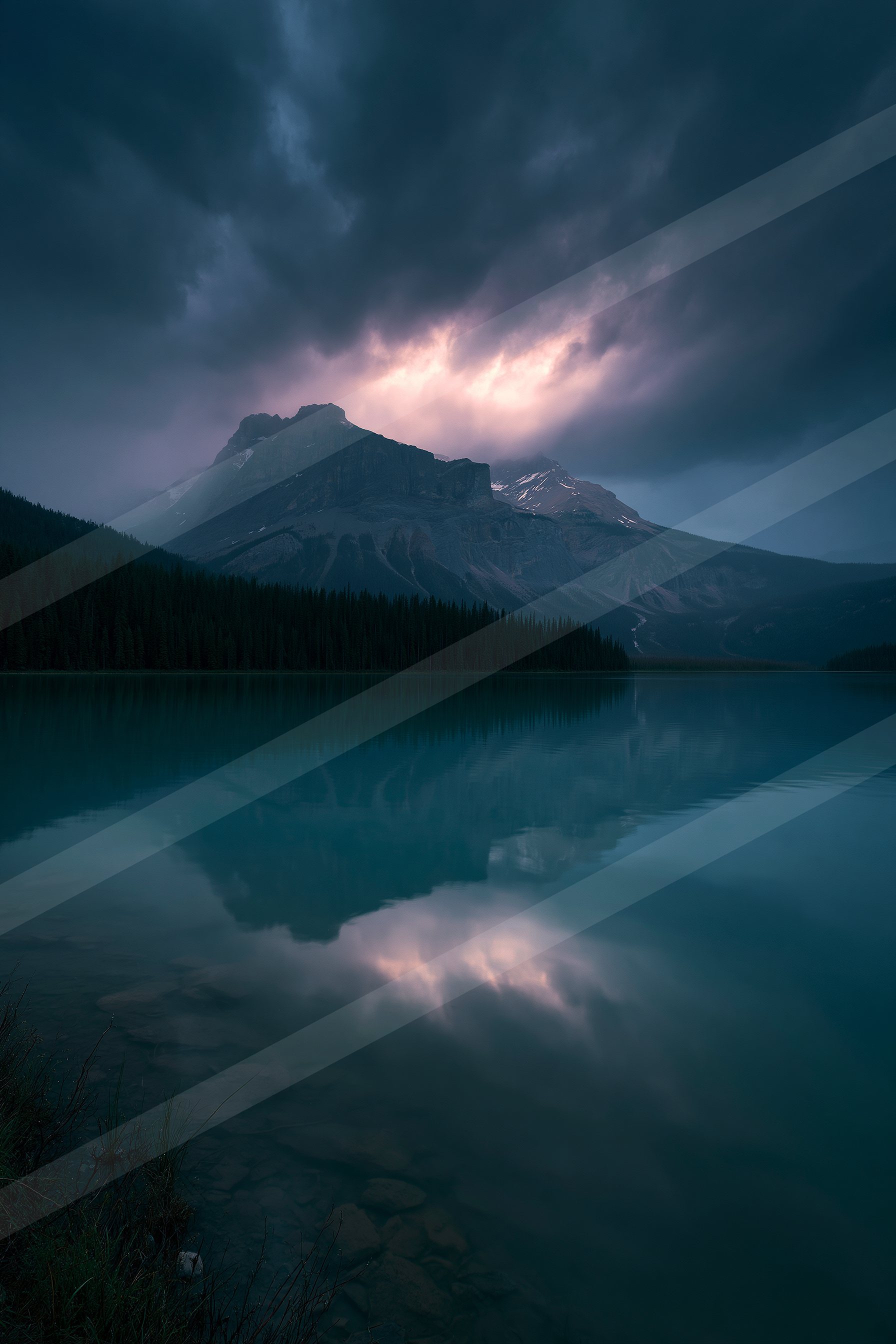A serene lake reflects the silhouette of a mountain under a moody, storm-laden sky.