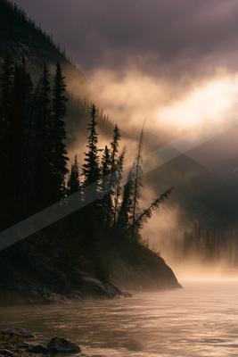 A brown-toned moody photograph of lakeside, valley, canoe.