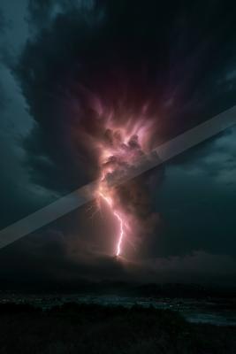 A powerful lightning bolt with pink and purple hues strikes down from a massive, turbulent storm cloud, illuminating the night sky above a dark landscape with a