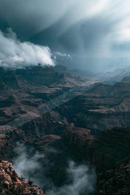 A moody landscape of mountains, valley, storm.