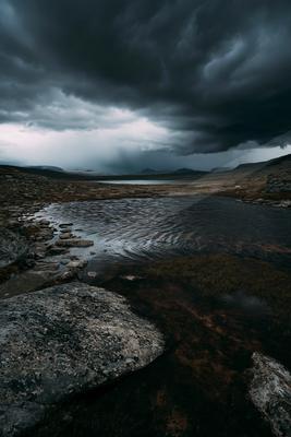 A black-and-white moody sky scene of storm, lake, clouds.
