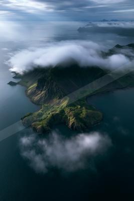 A serene aerial water scene of ocean, mountains, valley.