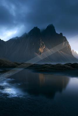 A blue hour long exposure landscape of mountains, lake, reflection.