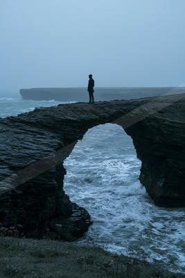 A moody architecture photo of bridge, ocean.