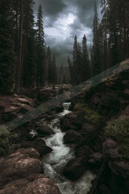 A black-and-white dramatic long exposure water scene of river, valley, fog.