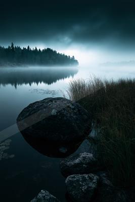 A mysterious long exposure water scene of a lake, fog.