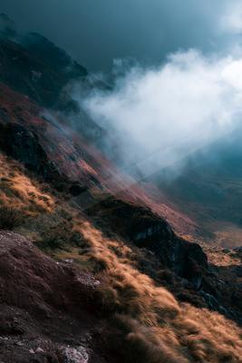 A moody landscape of mountains, valley.