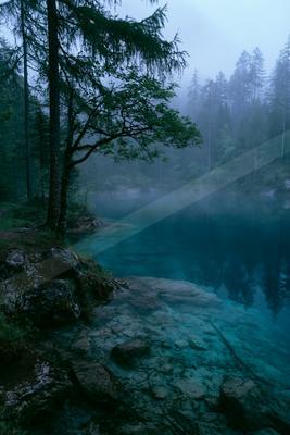 A blue hour water scene of a lake, fog.