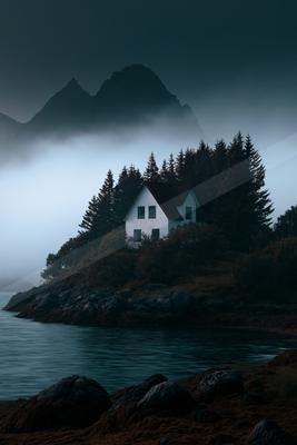 A moody landscape of mountains, lake.