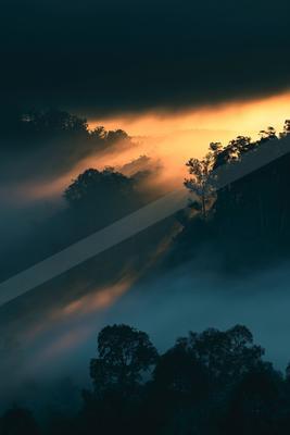 A dramatic sky scene of sunrise, clouds, fog.