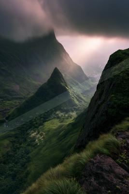 A moody landscape of mountains, valley.