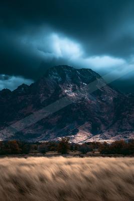 A dramatic long exposure sky scene of storm, mountains, valley.