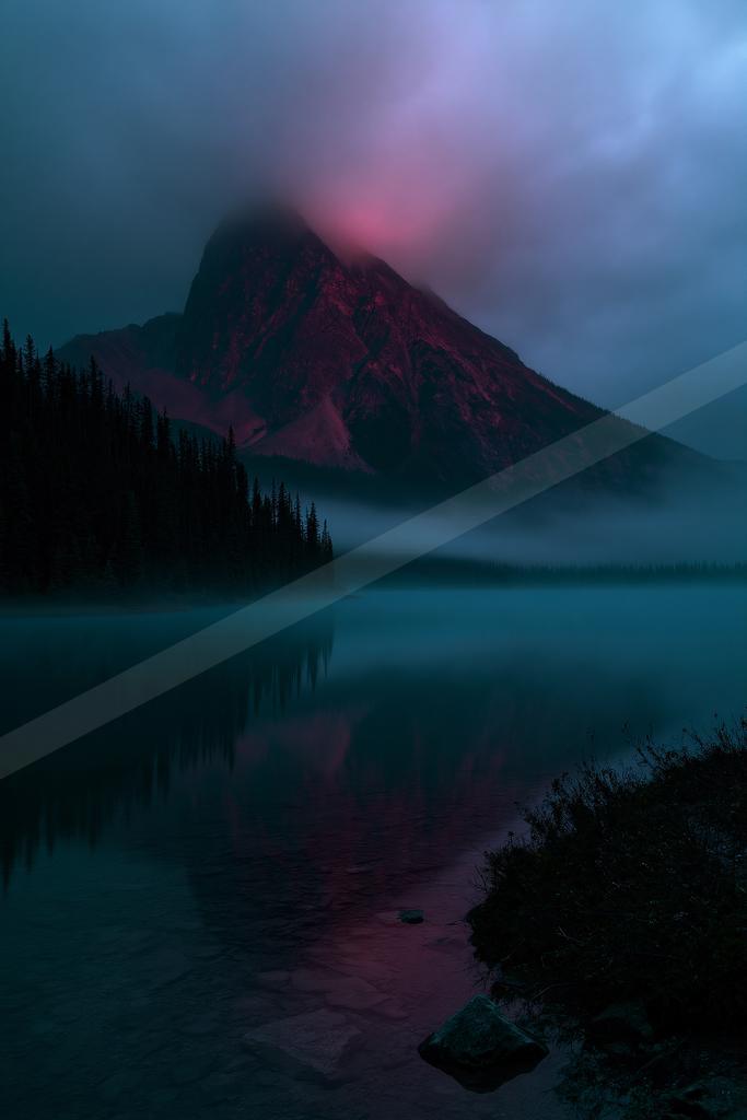 A black-toned moody photograph of volcano, alp, lakeside.