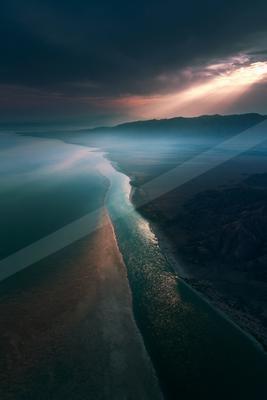 A blue hour long exposure water scene of beach, ocean, river.