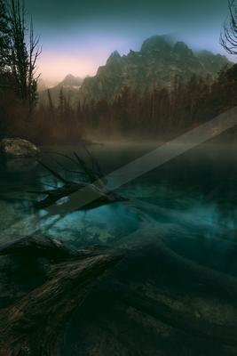 A serene water scene of lake, river, mountains.