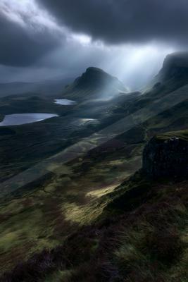 A dramatic landscape of valley, mountains, storm.
