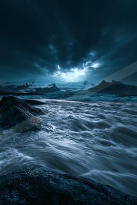 A black-toned moody photograph of wreck, seashore, breakwater.