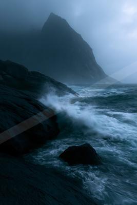 A black-toned moody photograph of promontory, seashore, cliff.